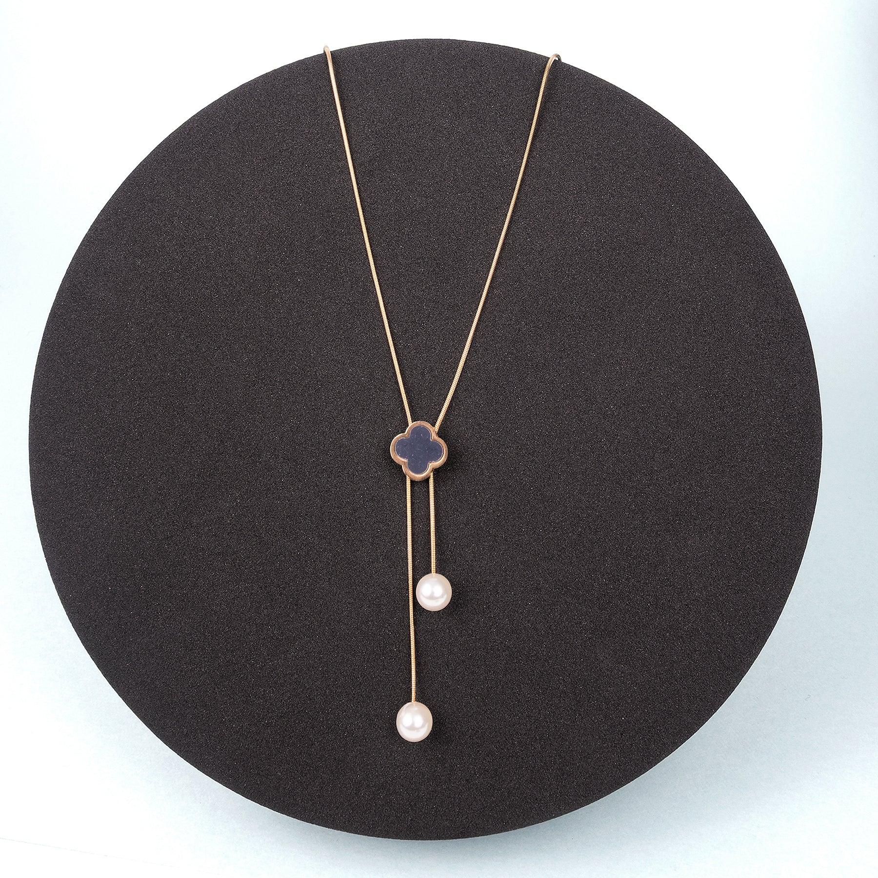 Necklace with a pendant and two pearl drops on a black stand