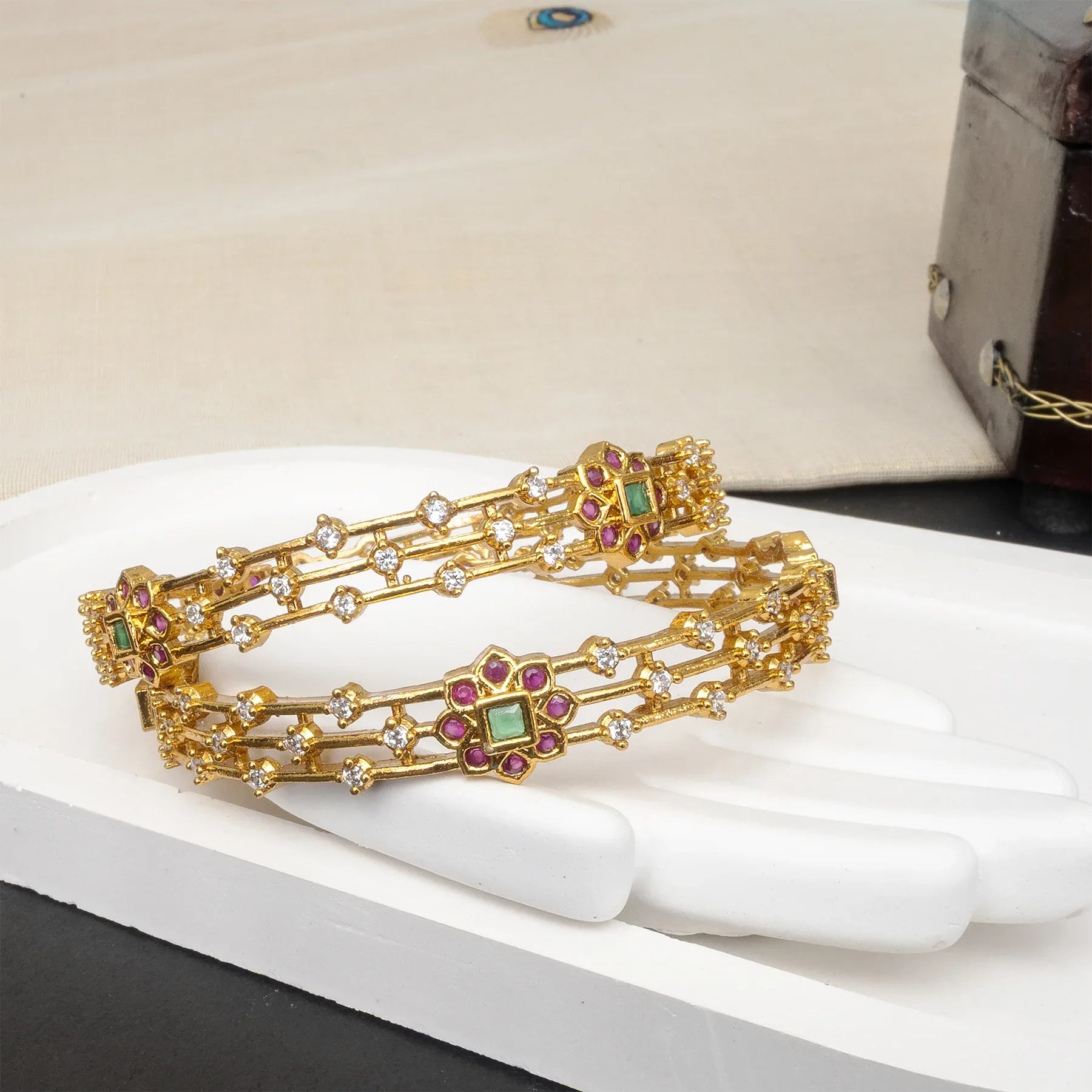 Gold bracelet with gemstones on a white surface