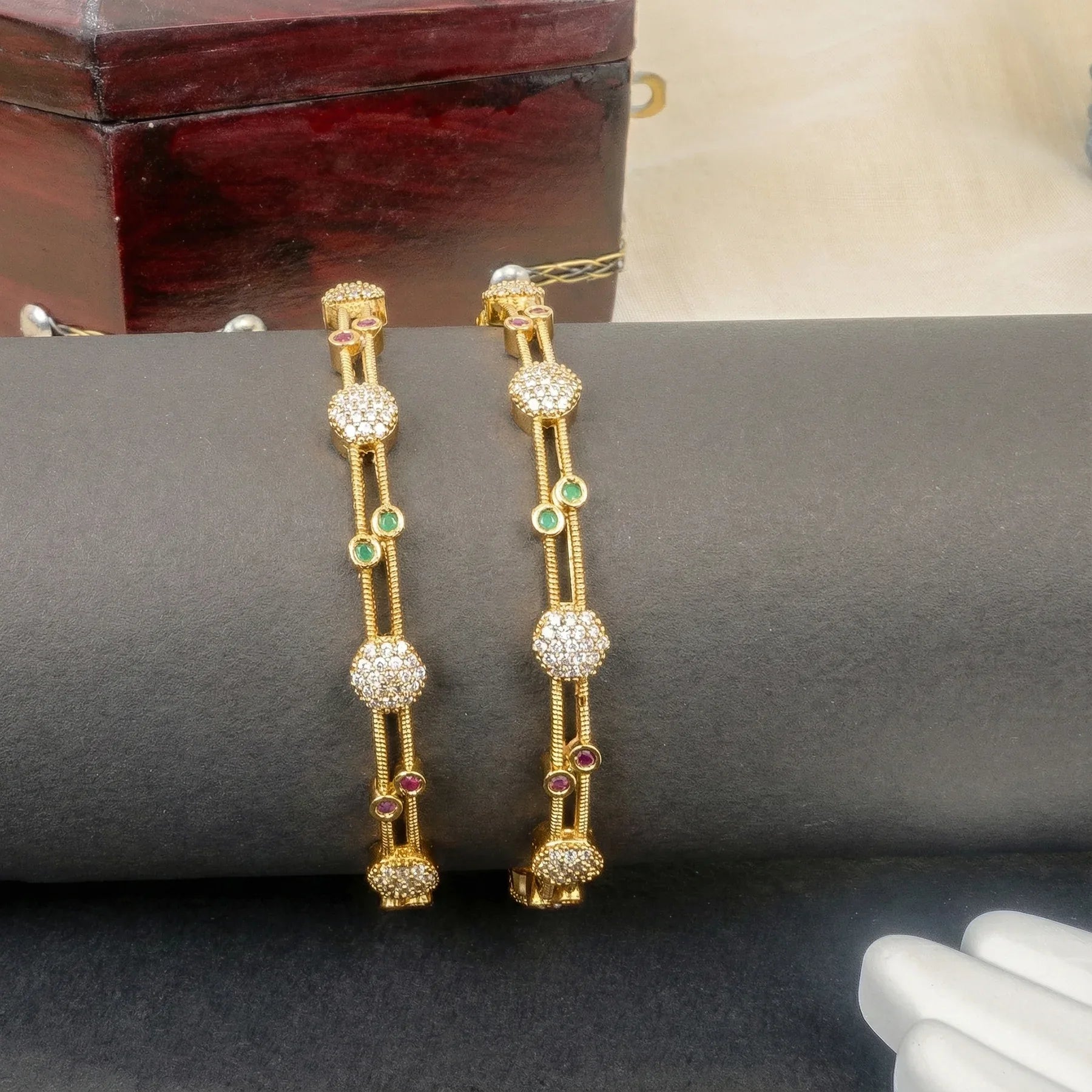 Gold earrings with gemstones on a dark surface