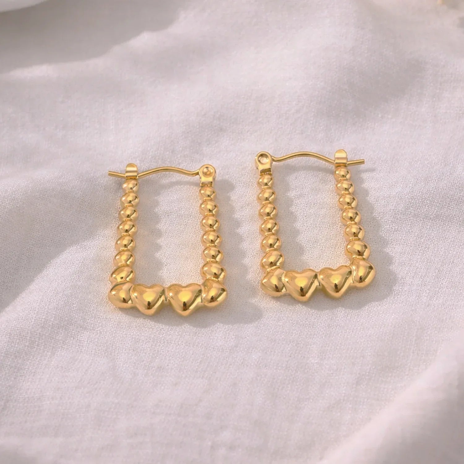 Gold hoop earrings on a light fabric background