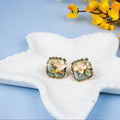Pair of floral earrings on a starfish with yellow flowers in the background