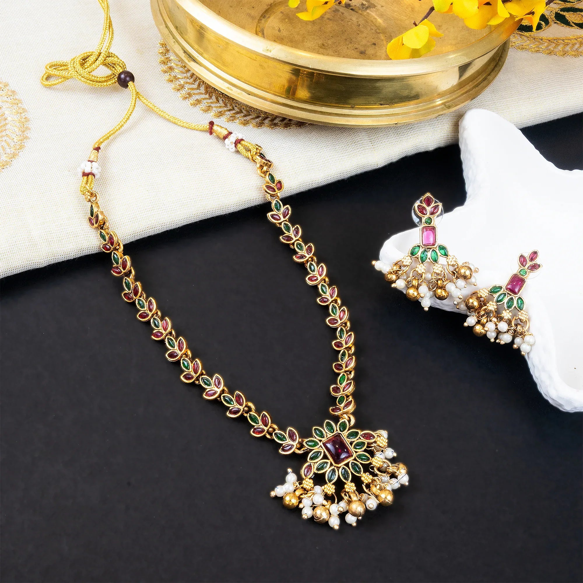 Gold necklace with gemstones on a dark surface