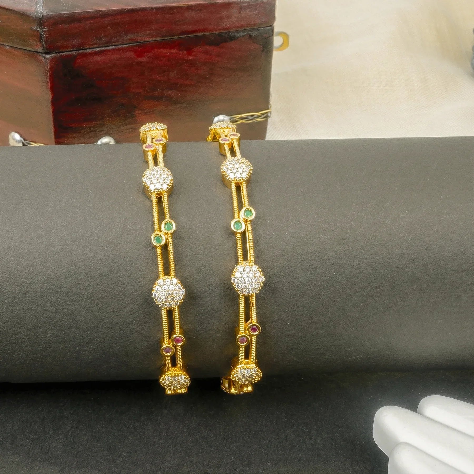 Gold earrings with gemstones on a dark surface