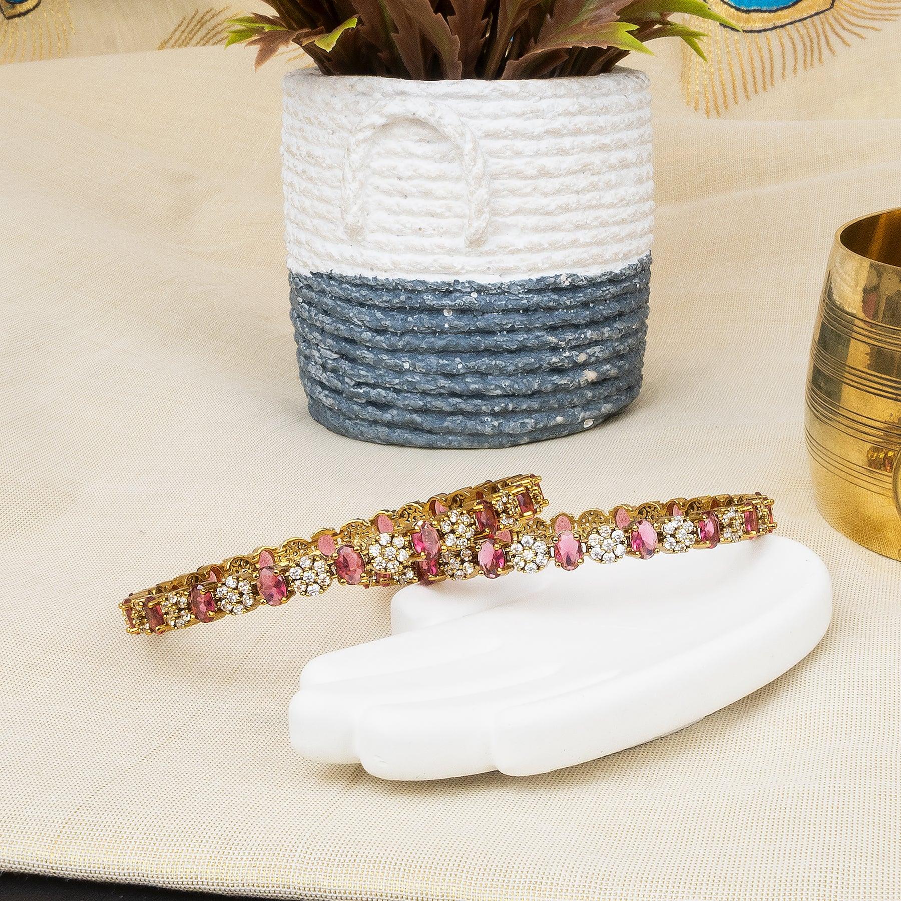 Decorative headband with pink and gold accents on a white surface, with a plant and decorative item in the background.