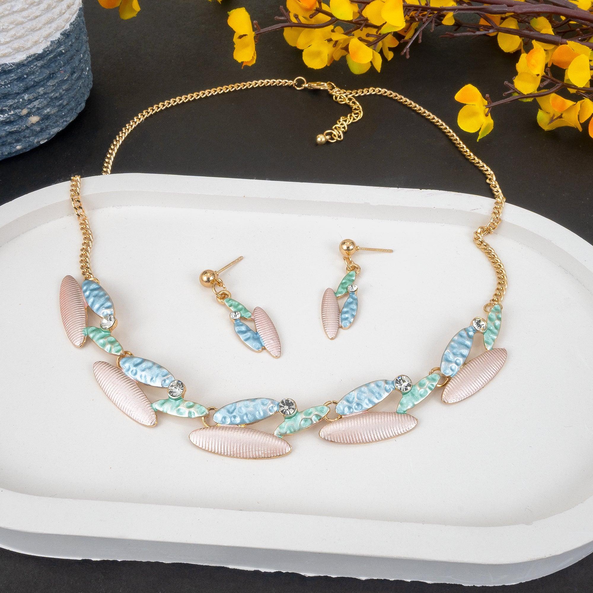 Jewelry set with necklace and earrings on a white dish with yellow flowers in the background