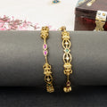 Gold earrings with gemstones on a dark surface