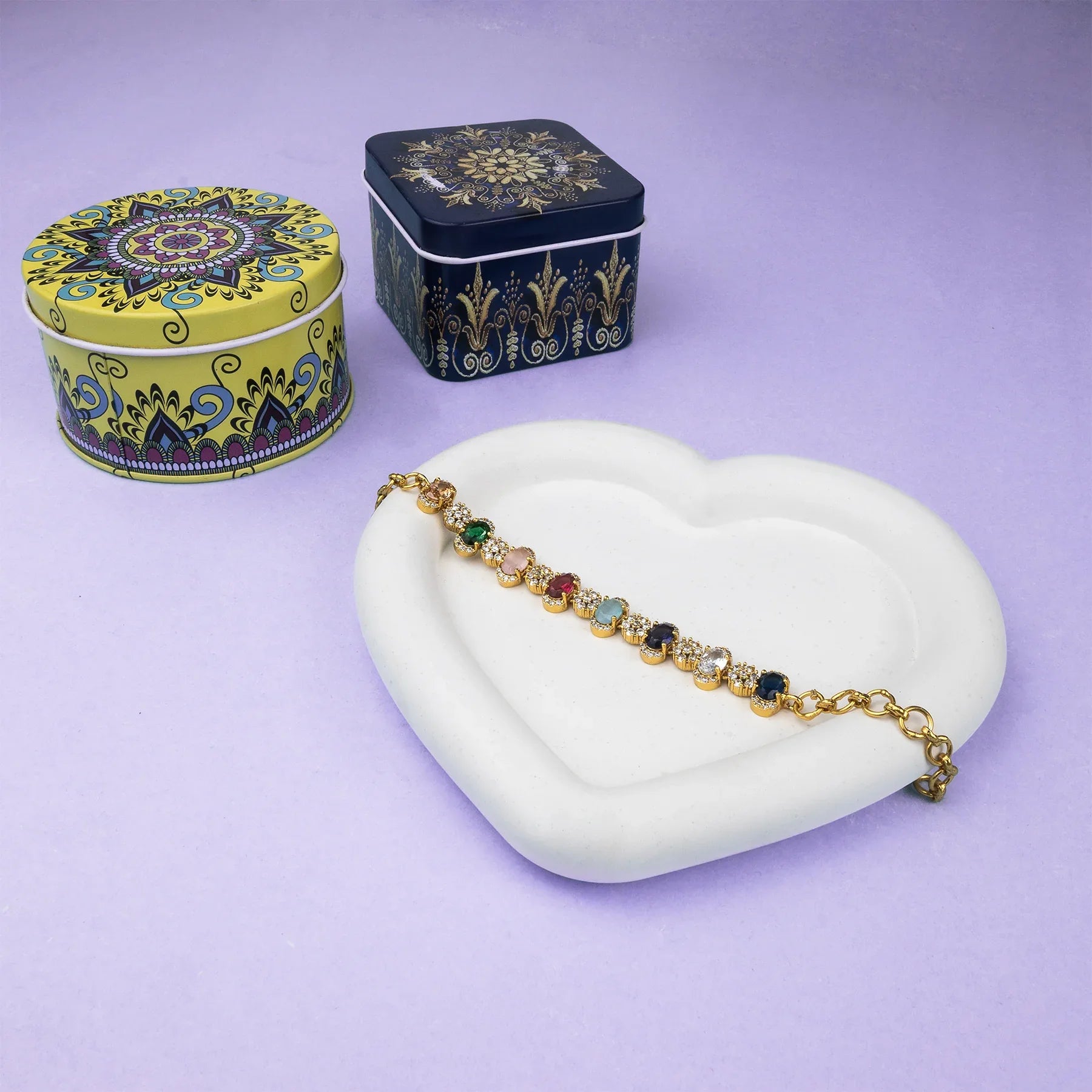 Colorful bracelet on a white heart-shaped stand with decorative tins in the background