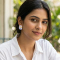 Woman wearing a white shirt with a blurred green outdoor background