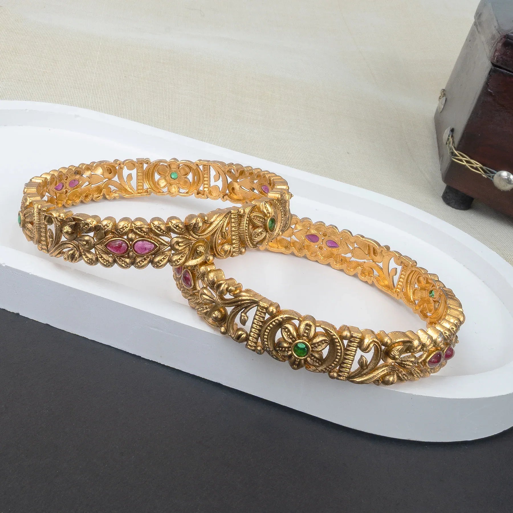 Gold bracelet with gemstones on a white surface