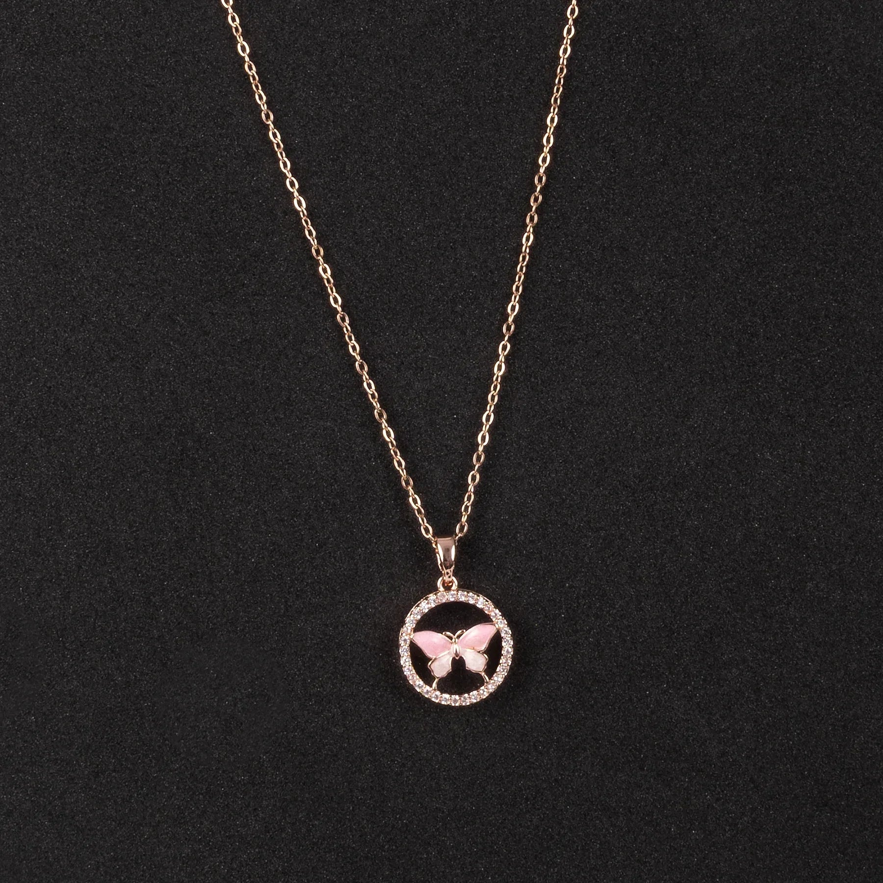 Rose gold necklace with a butterfly pendant on a black background
