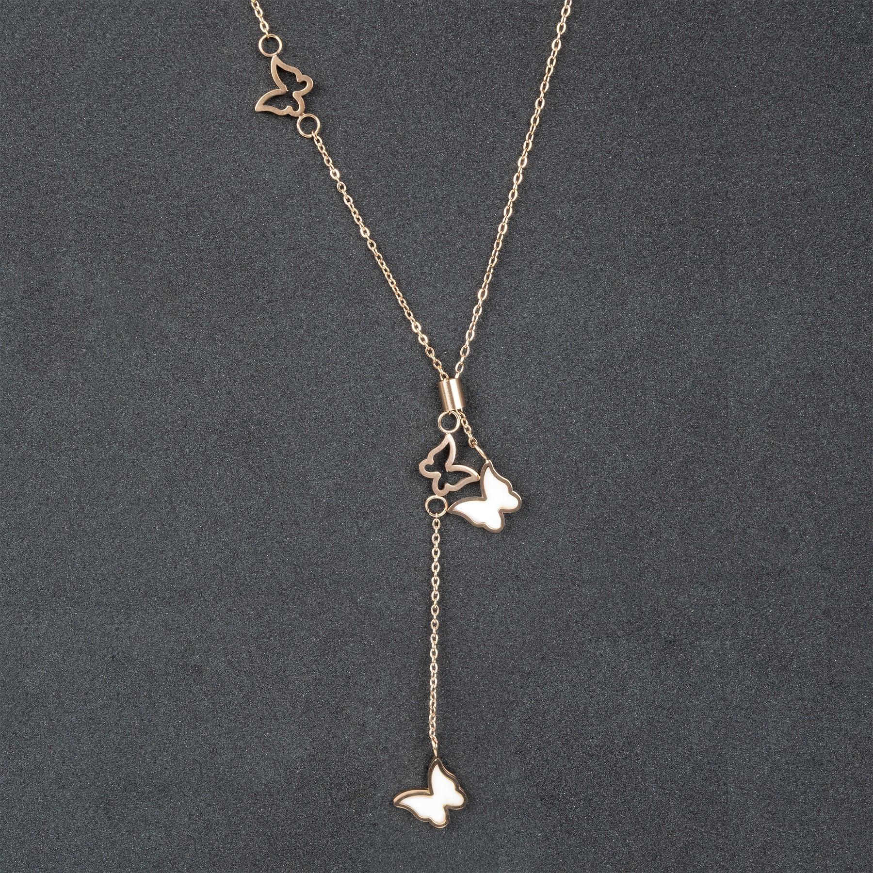 Gold butterfly necklace on a dark gray background