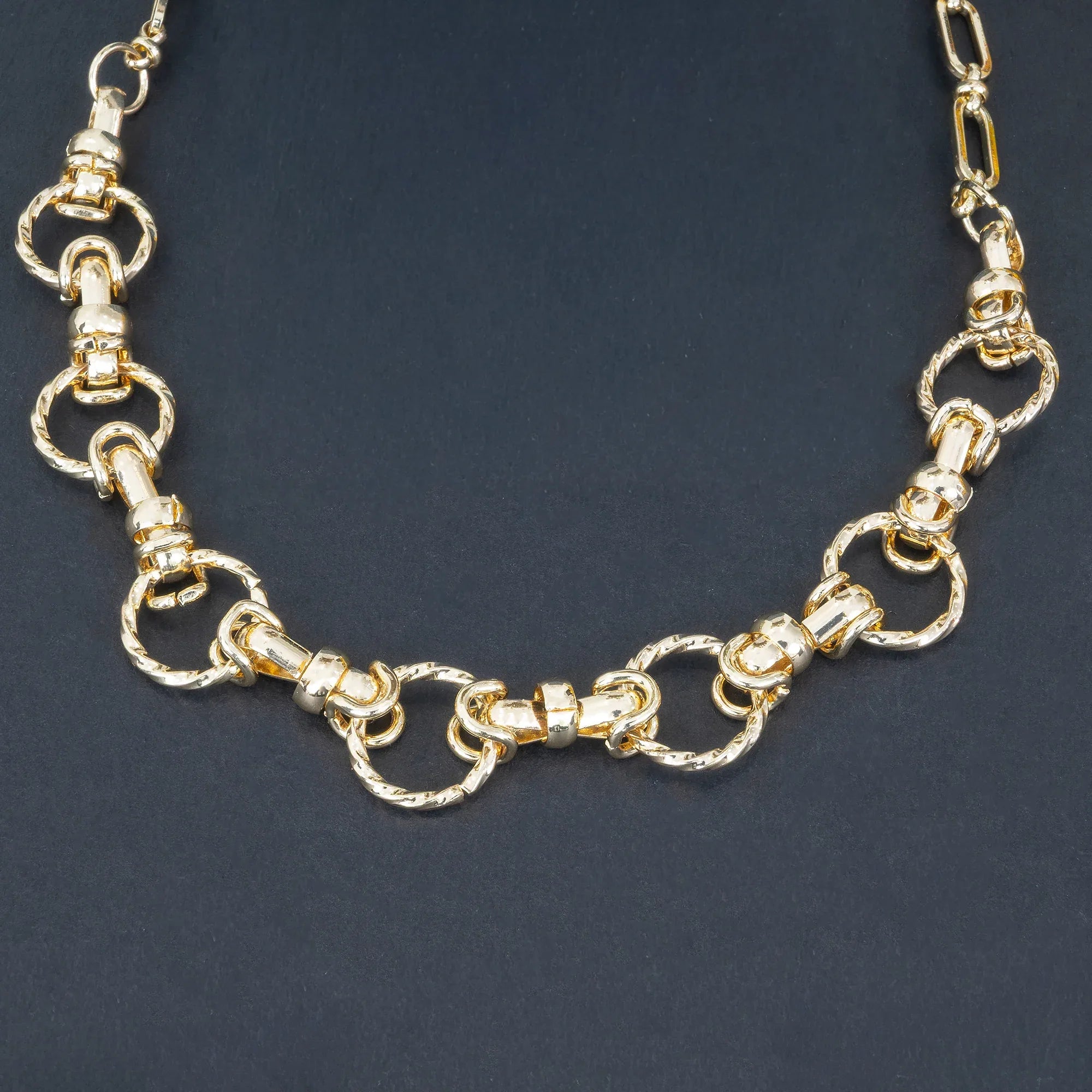 Gold chain necklace on a dark background