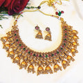 Gold necklace and earrings set with gemstones on a white background