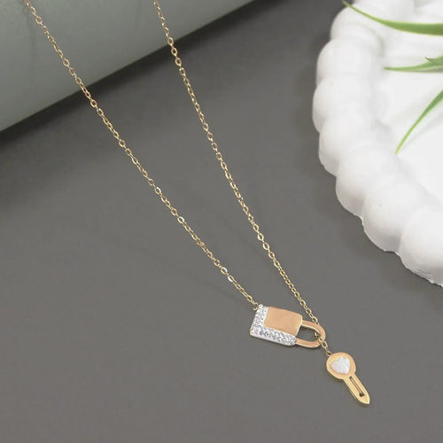 Gold necklace with lock and key pendants on a gray surface