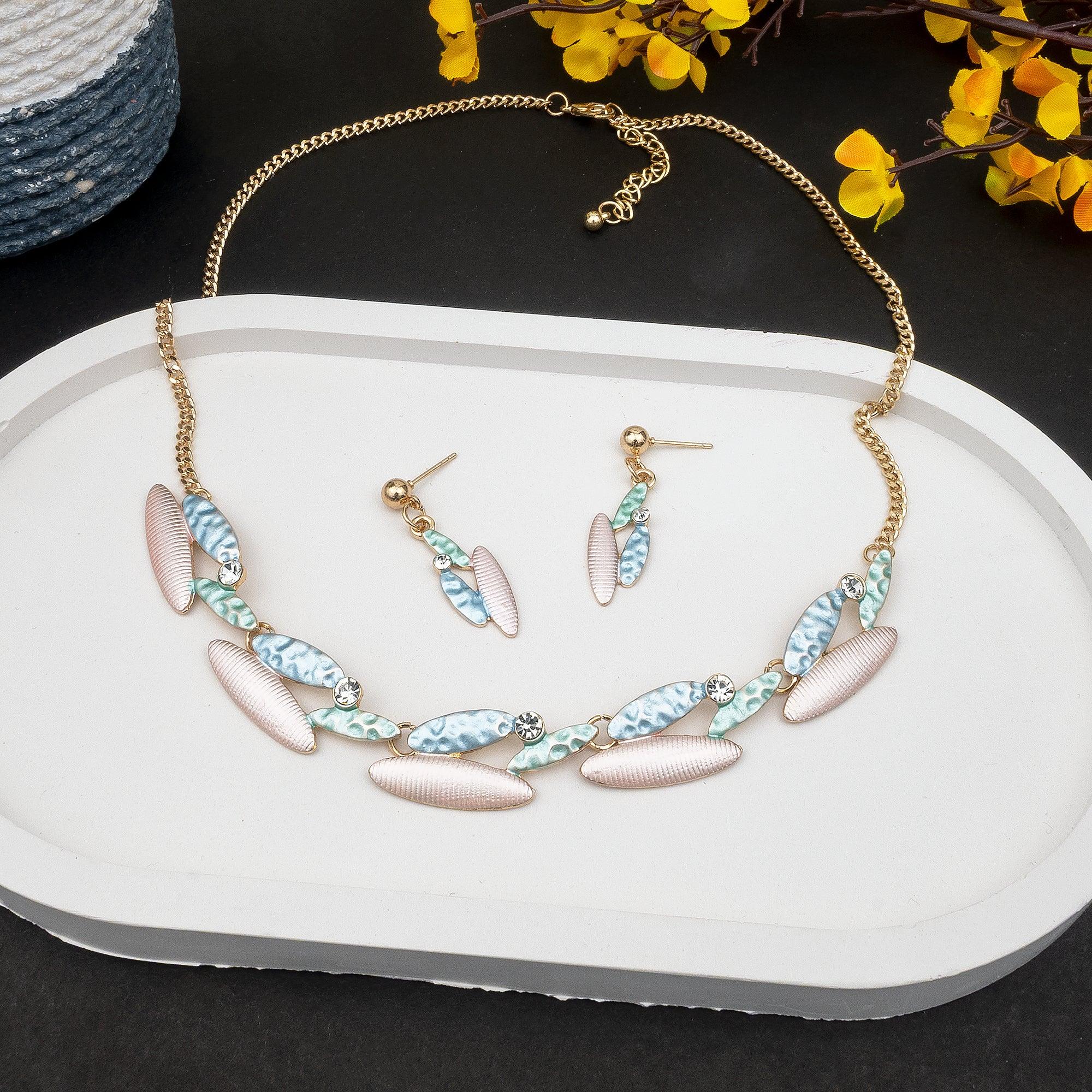 Jewelry set with necklace and earrings on a white tray with yellow flowers in the background