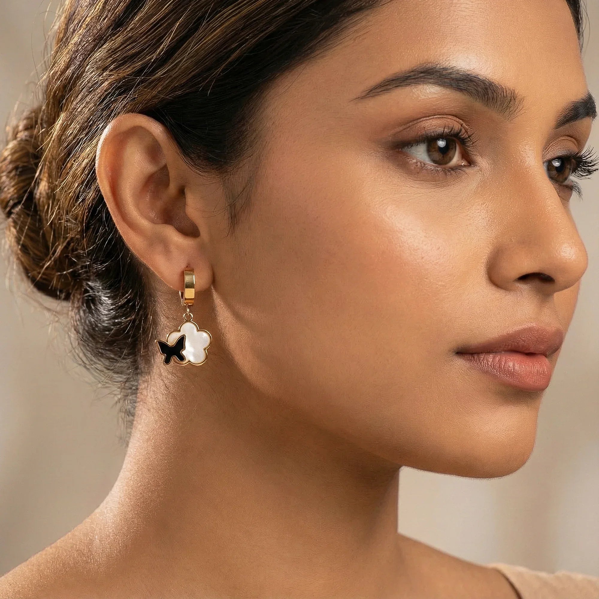 Close-up of a woman wearing an earring with a neutral background