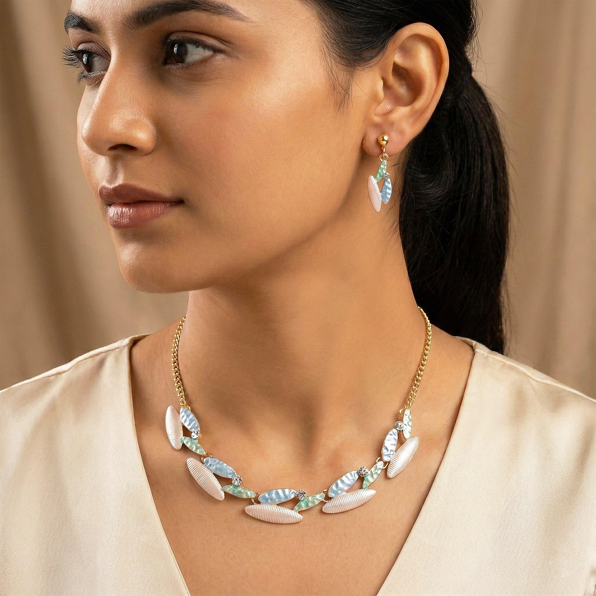 Woman wearing a necklace and earrings with a neutral background