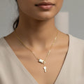 Gold necklace with a lock and key pendant on a neutral background