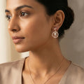 Close-up of a woman wearing a gold earring with a beige background
