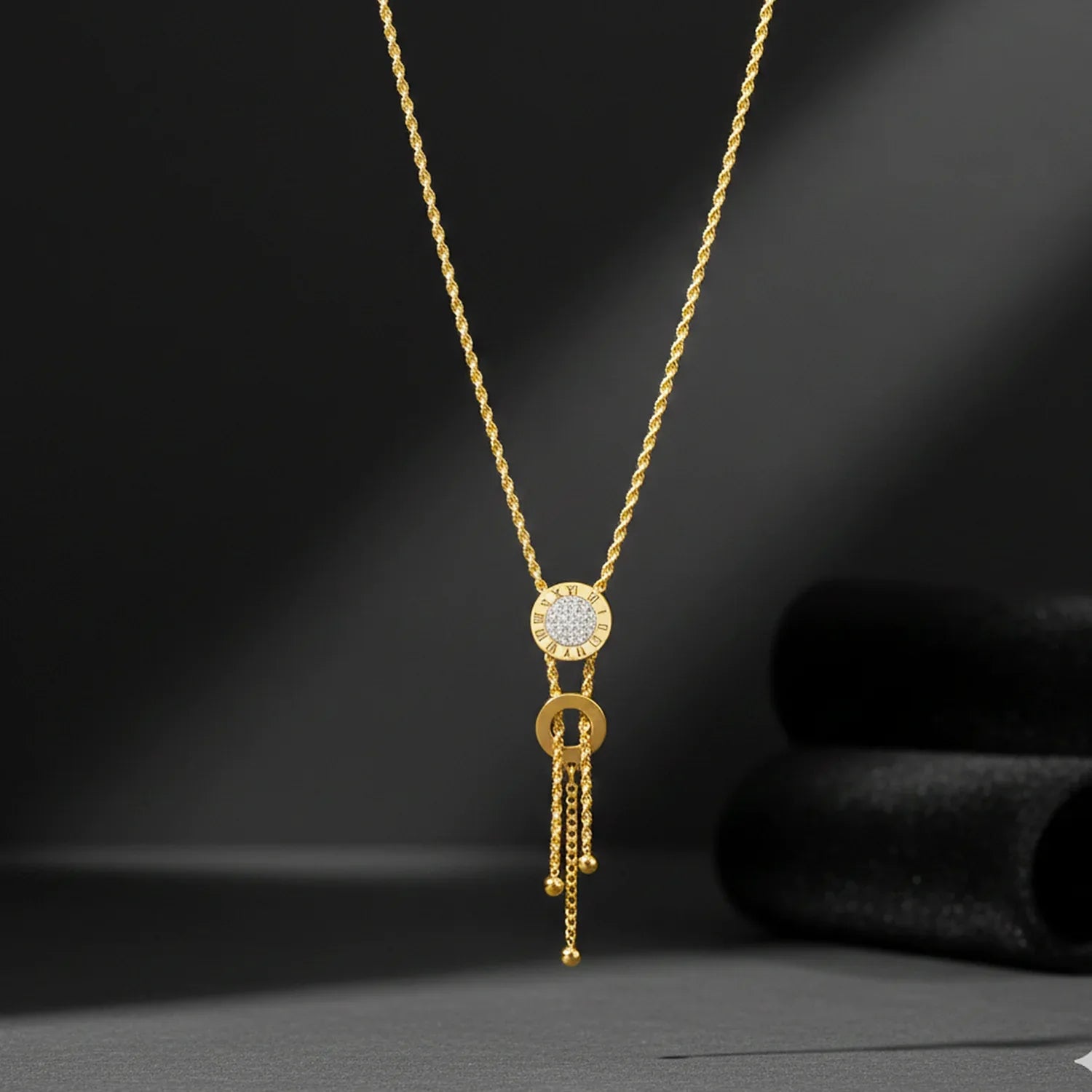 Gold necklace with a pendant on a dark background
