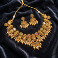 Gold necklace and earrings set on a dark velvet background