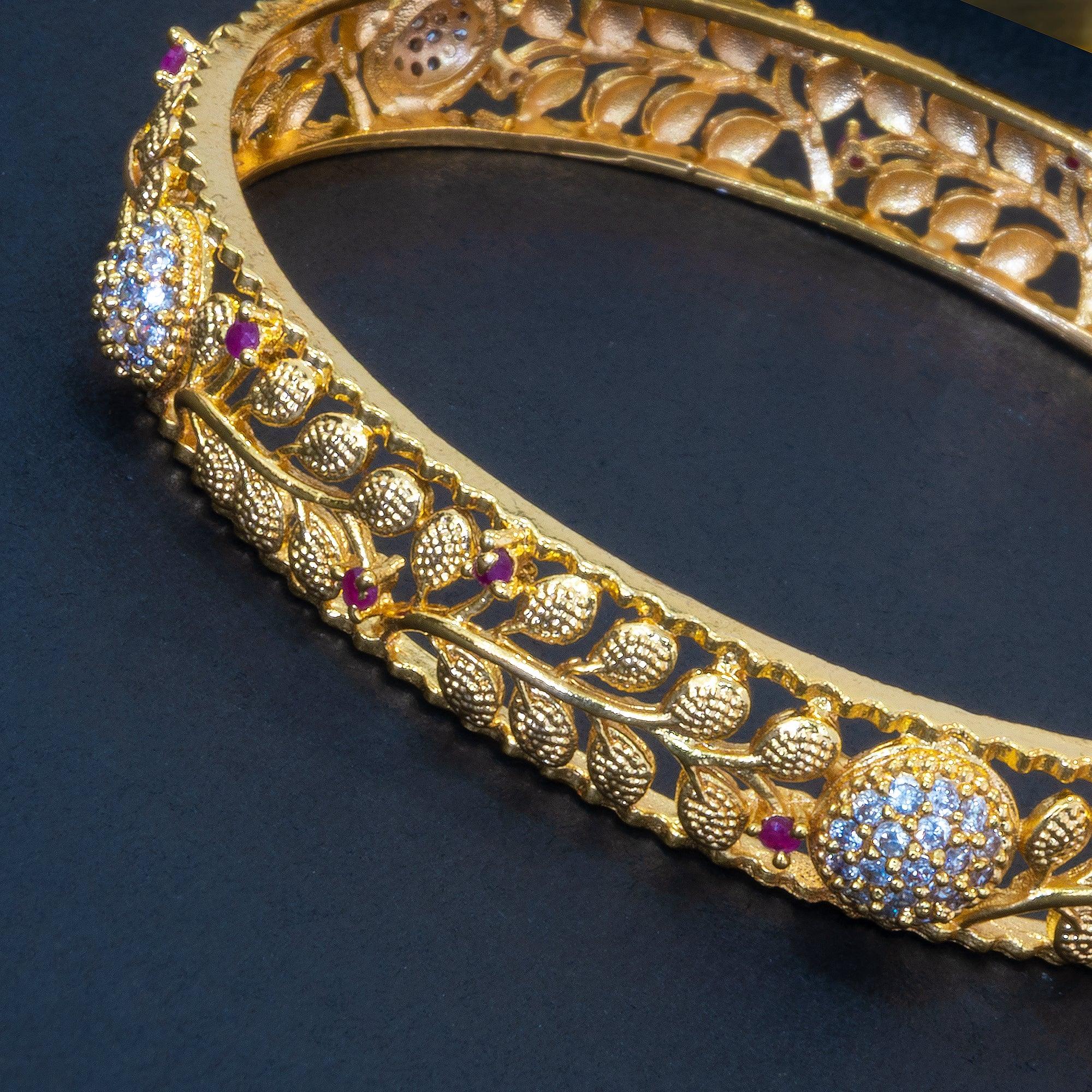 Gold bracelet with gemstones on a dark background