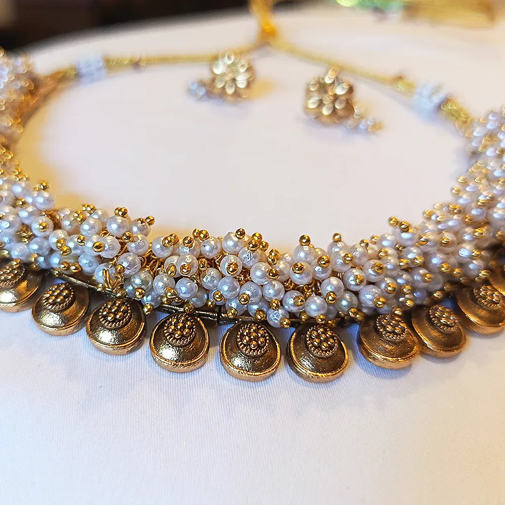 Necklace with pearls and gold coins on a white background