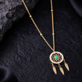 Gold necklace with a dreamcatcher pendant on a dark textured surface
