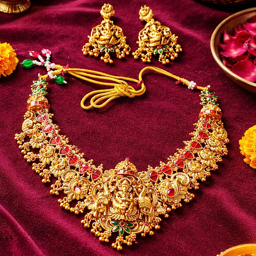 Gold necklace and earrings on a red fabric background