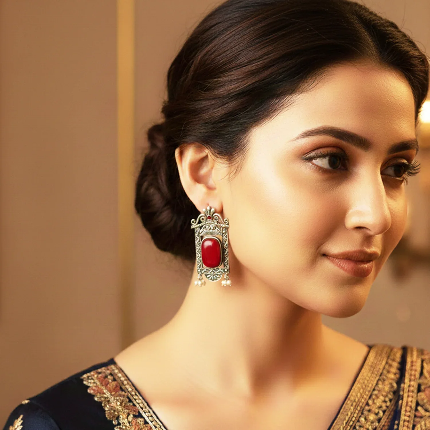 Woman wearing a red gemstone earring with a blurred background