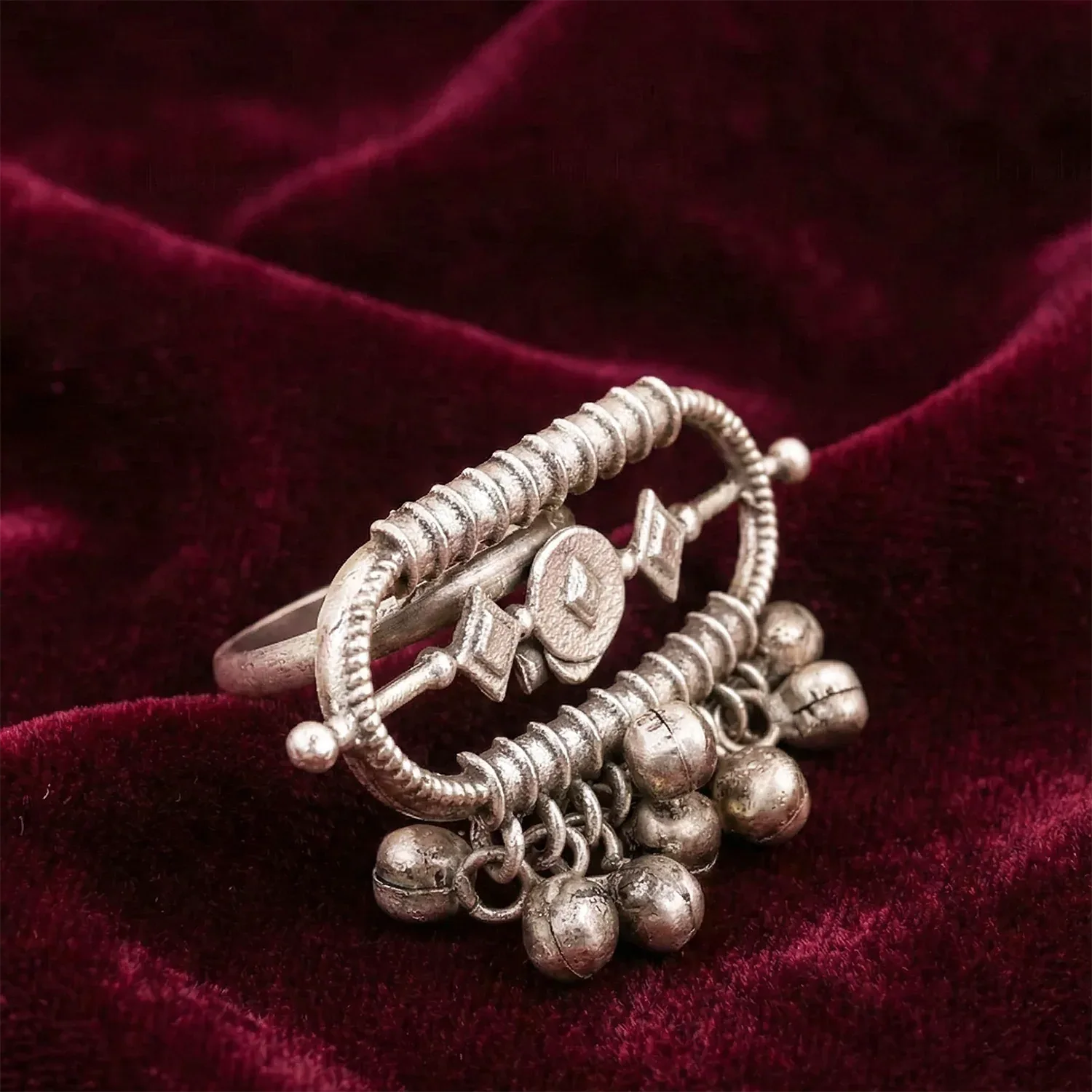 Silver ring with decorative elements on a red velvet background