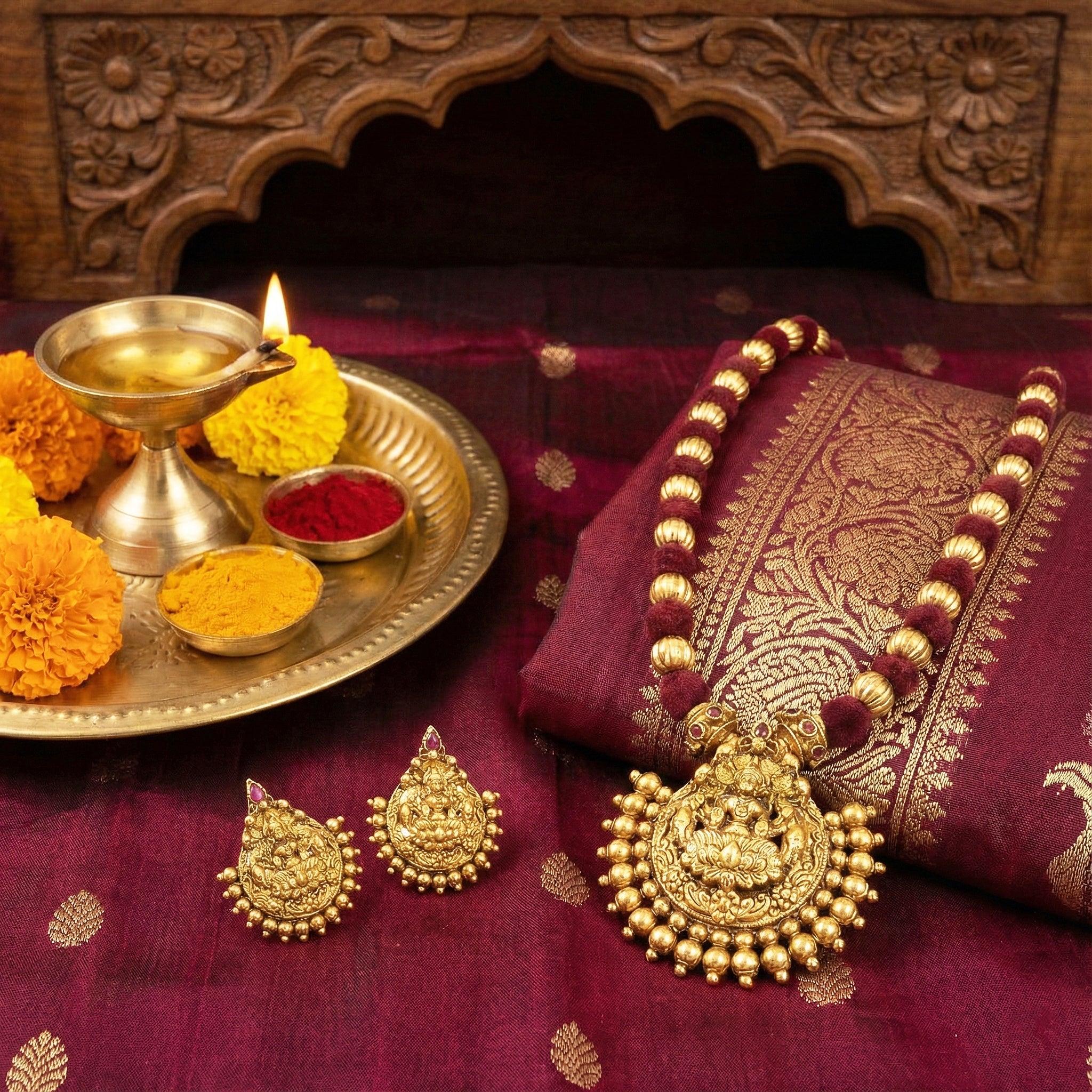 Gold jewelry on a maroon fabric with a decorative wooden background