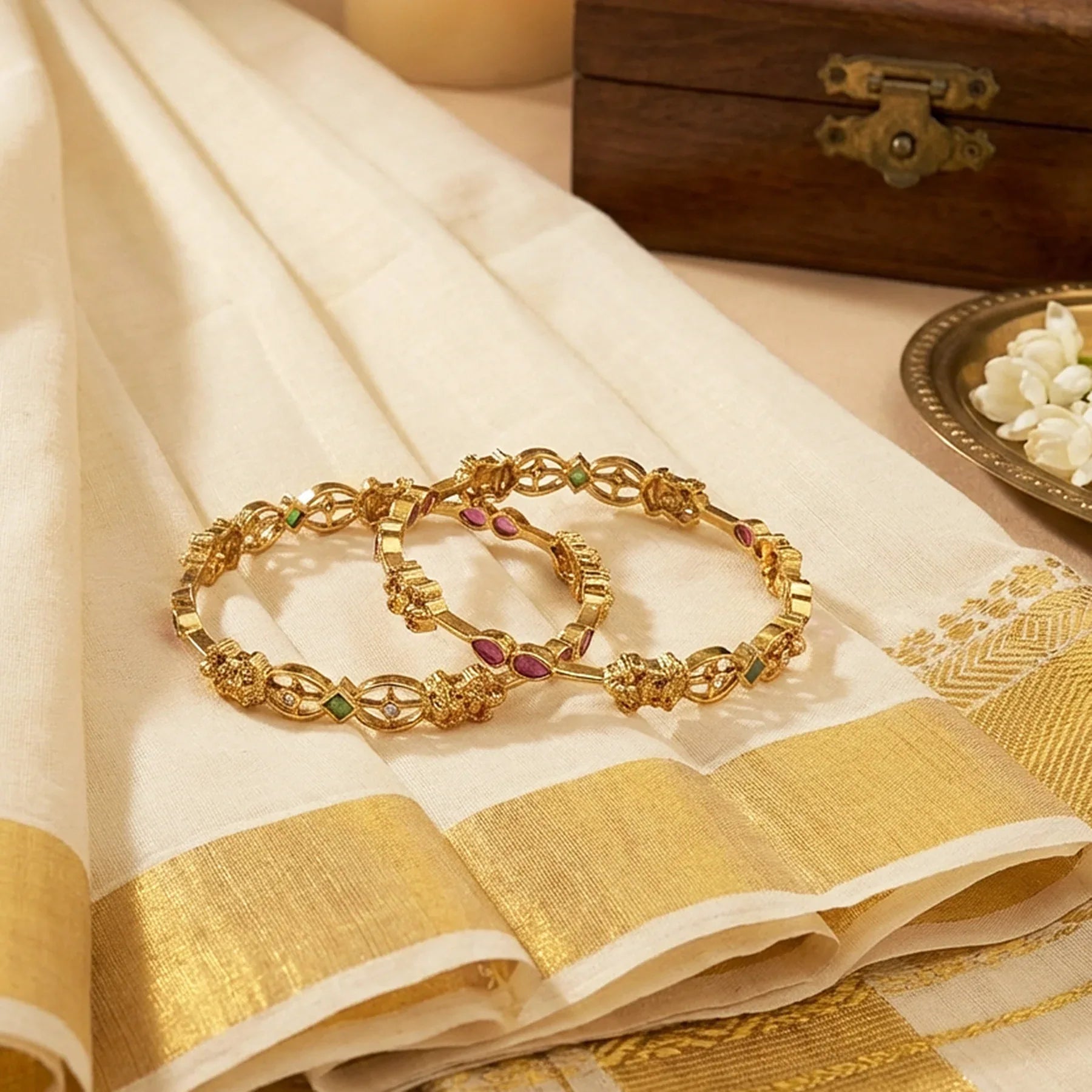 Gold jewelry on a white saree with gold border