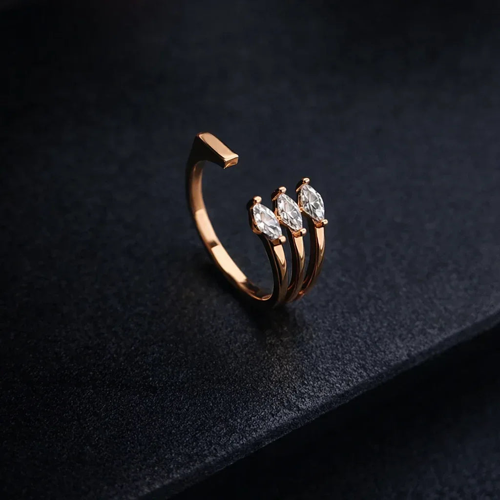Rose gold ring with three diamonds on a dark textured background