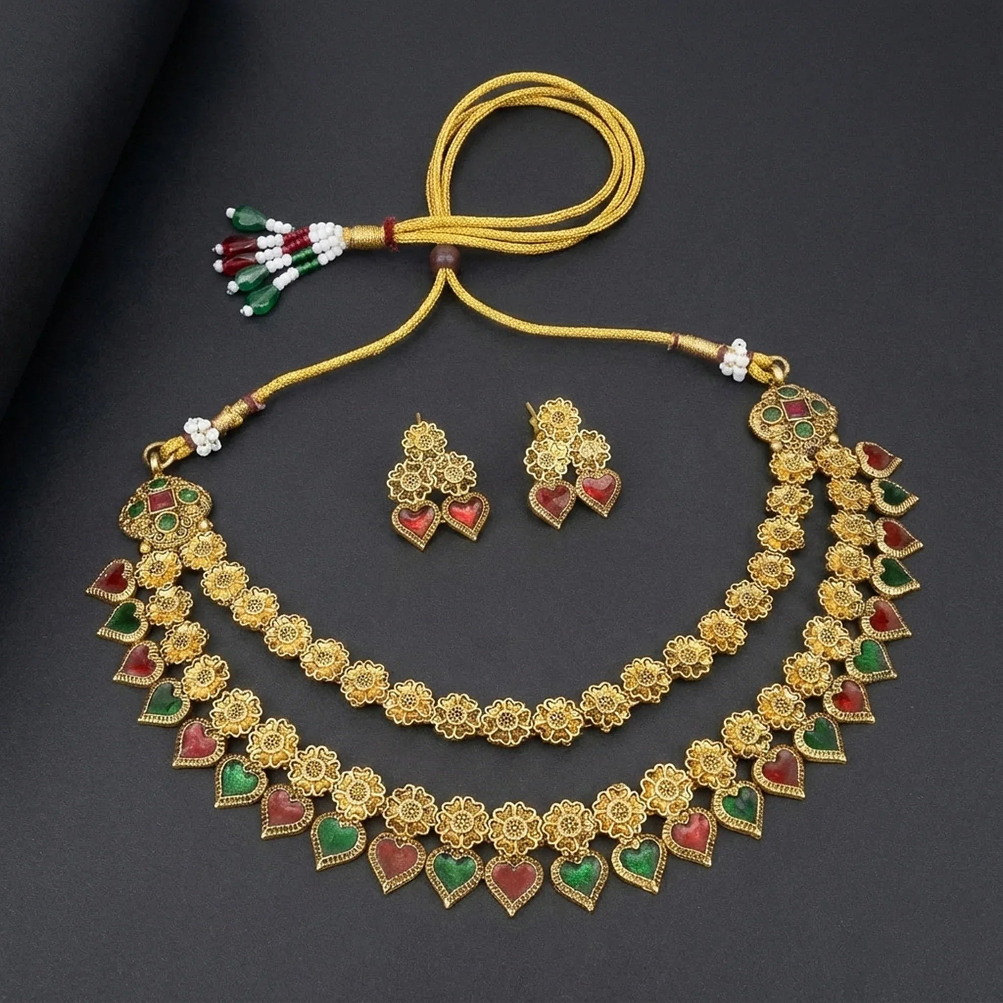 Gold necklace with heart-shaped gemstones on a dark background