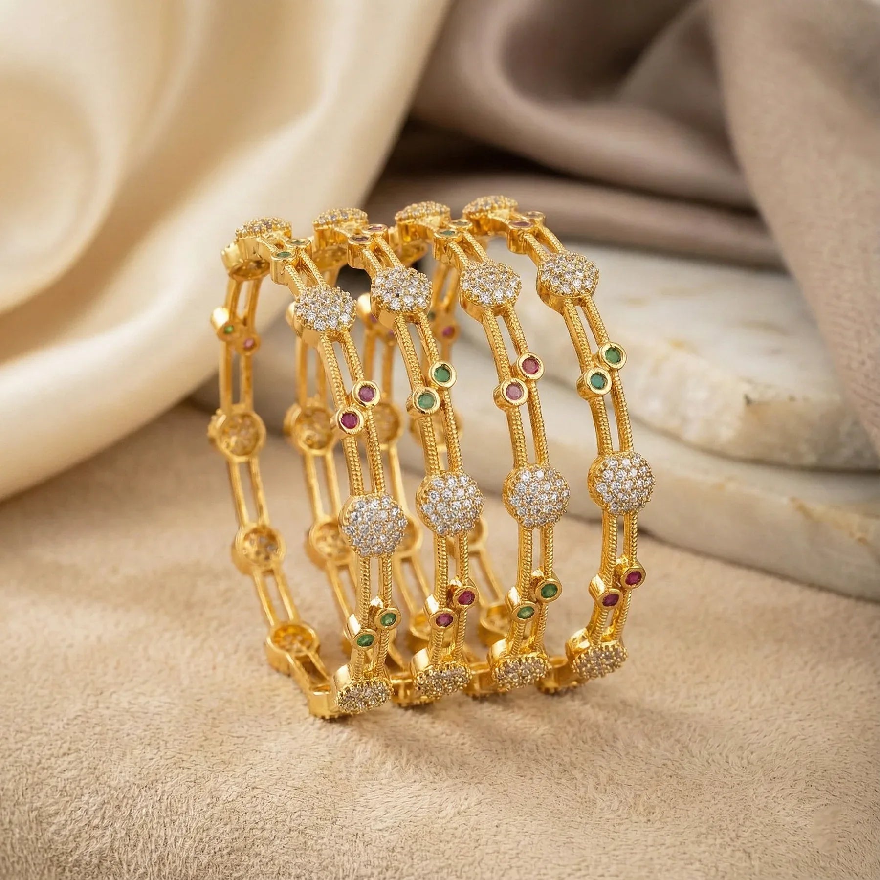 Gold bracelet with gemstones on a beige fabric background