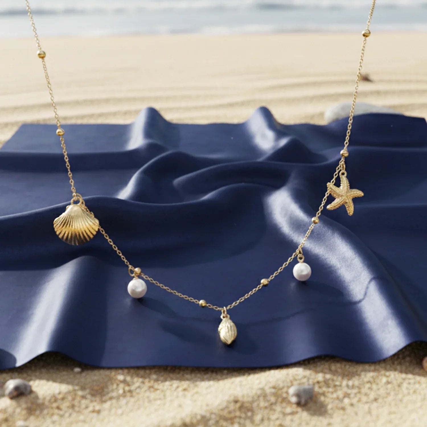 Necklace with shell and starfish pendants on a blue shell with beach background