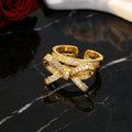 Gold bow-shaped ring with diamonds on a black marble surface