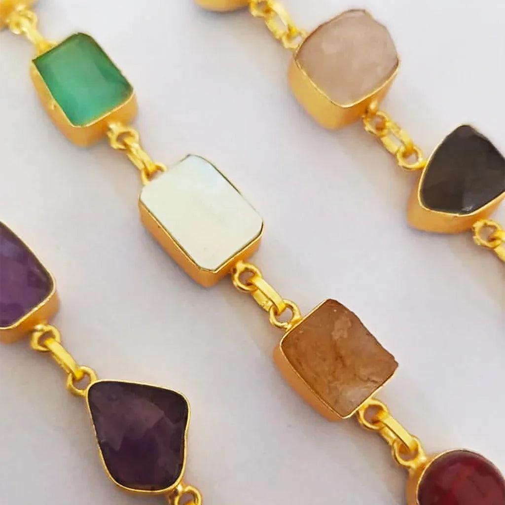 Gold necklace with colorful gemstones on a white background