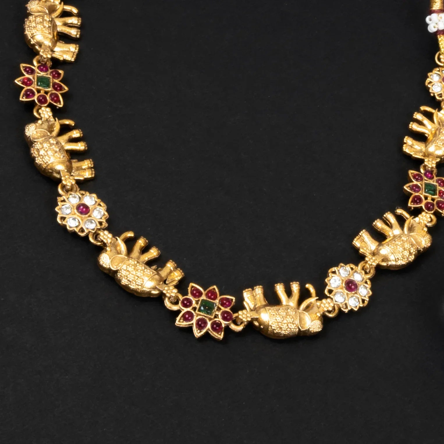 Gold necklace with decorative elements on a black background