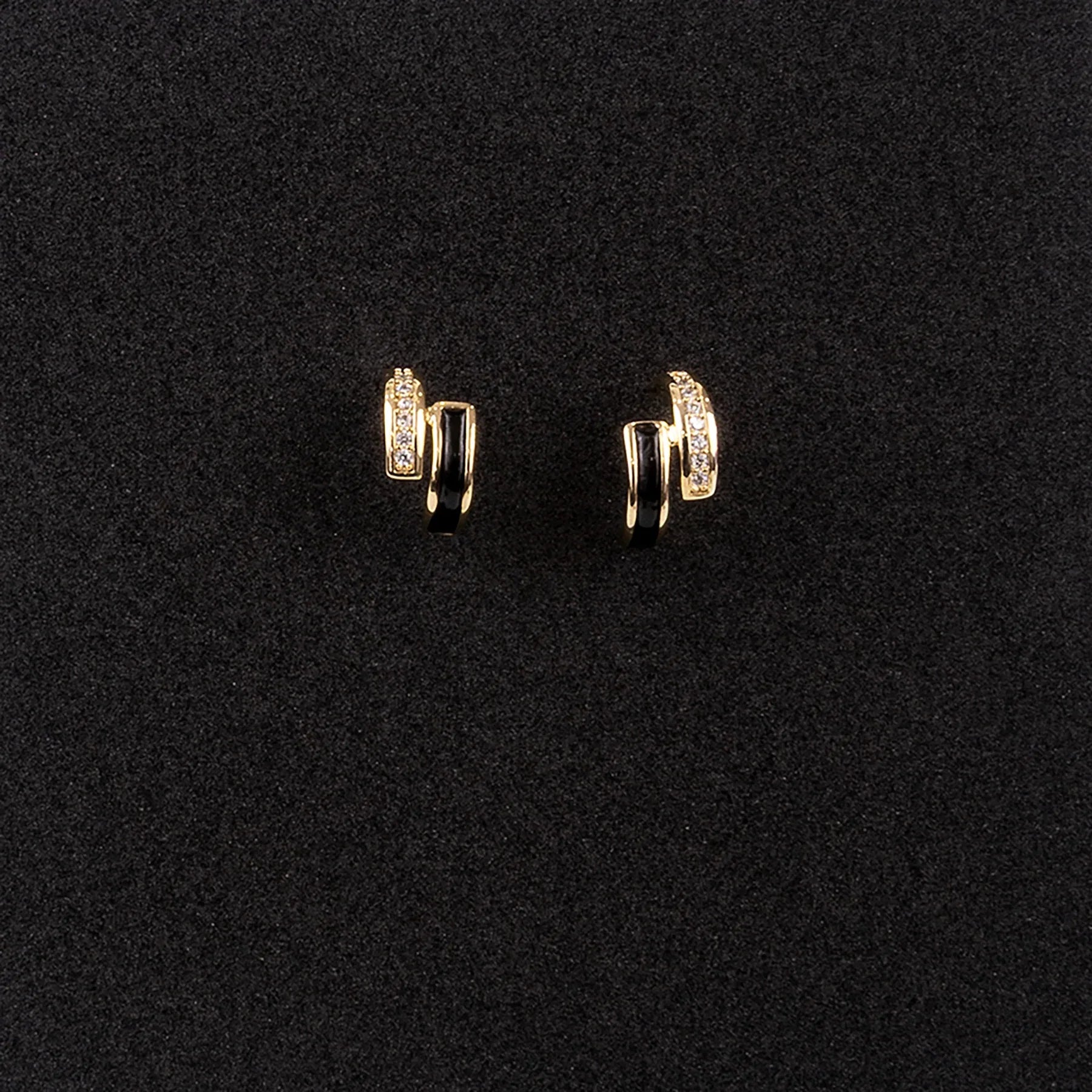 Pair of gold hoop earrings on a black background