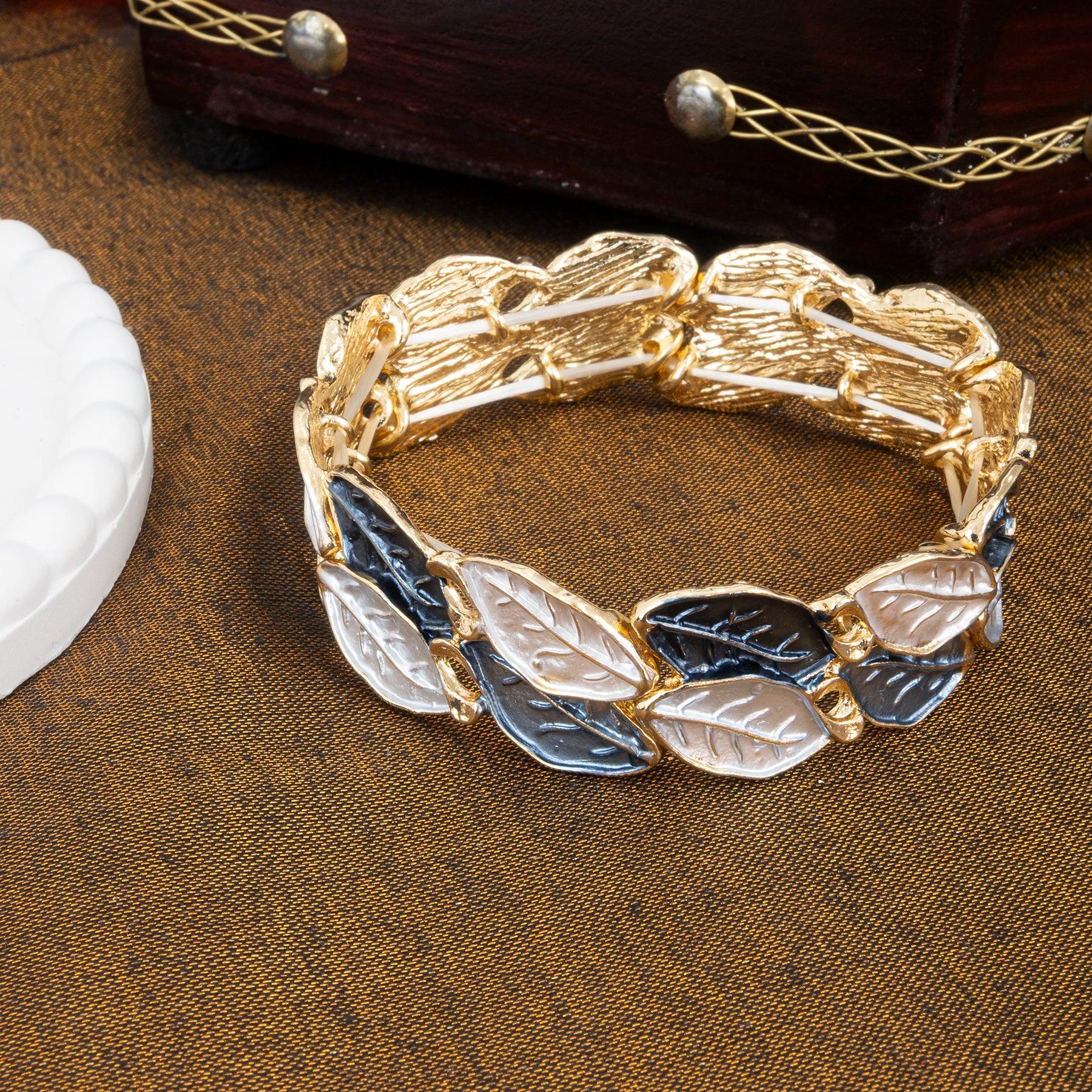 Gold bracelet with leaf designs on a brown surface