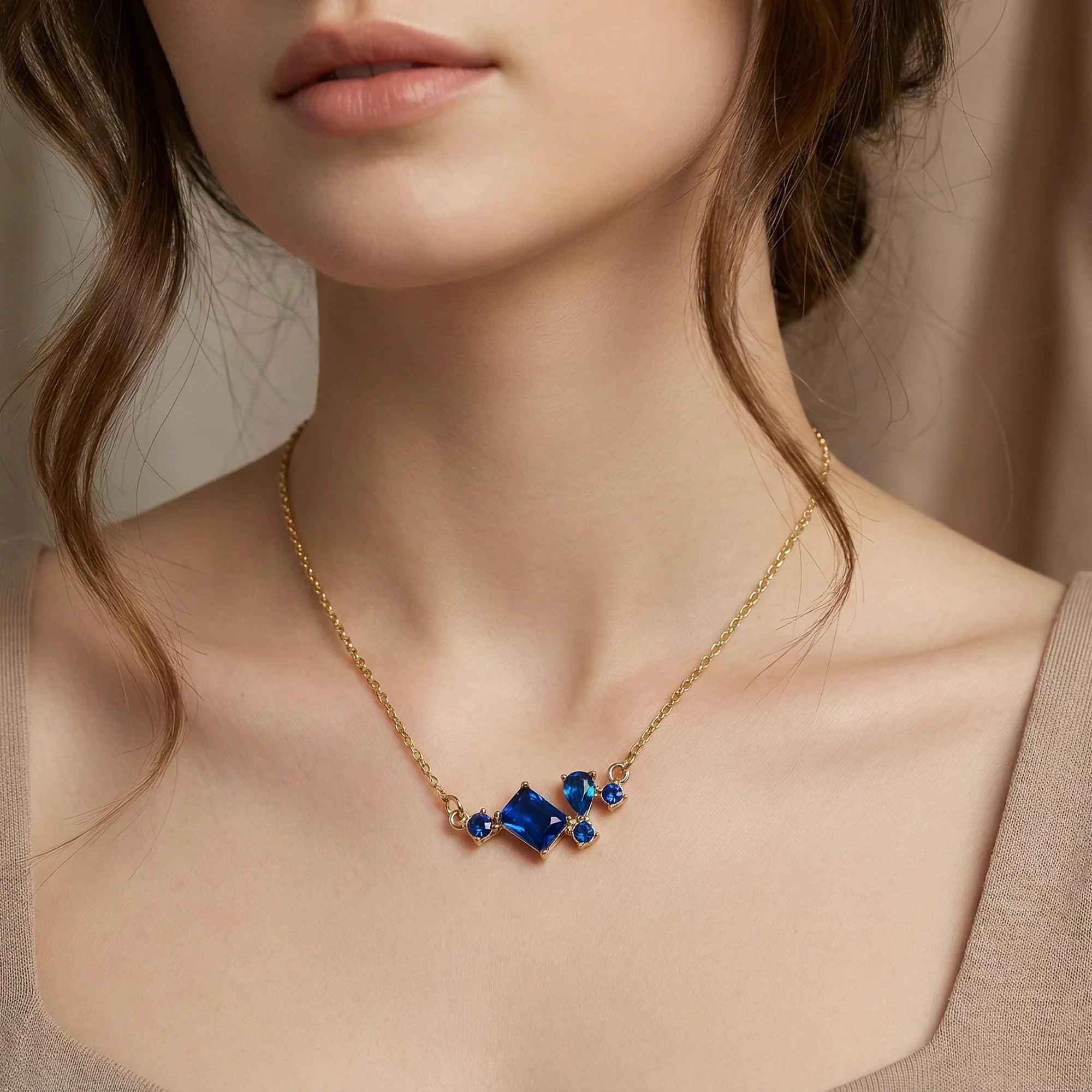Gold necklace with blue gemstones worn by a model