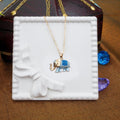Gold necklace with a blue elephant pendant on a white tray.