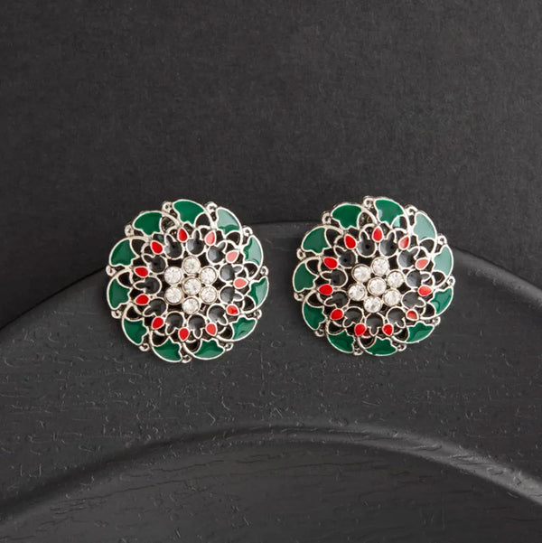 Pair of decorative earrings with green, red, and white design on a black background