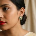 Close-up of a woman wearing a floral earring with a neutral background