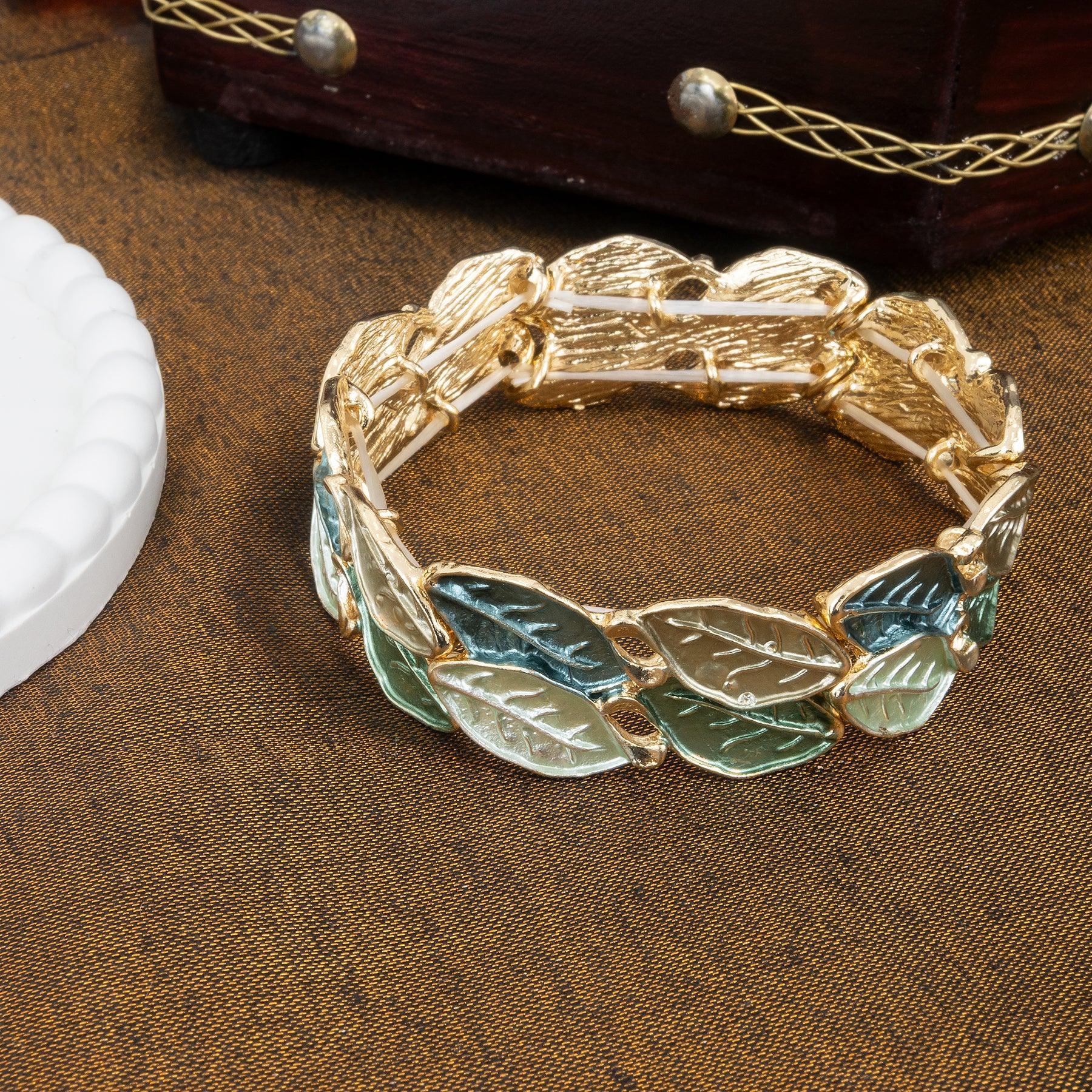 Gold bracelet with leaf designs on a brown textured surface
