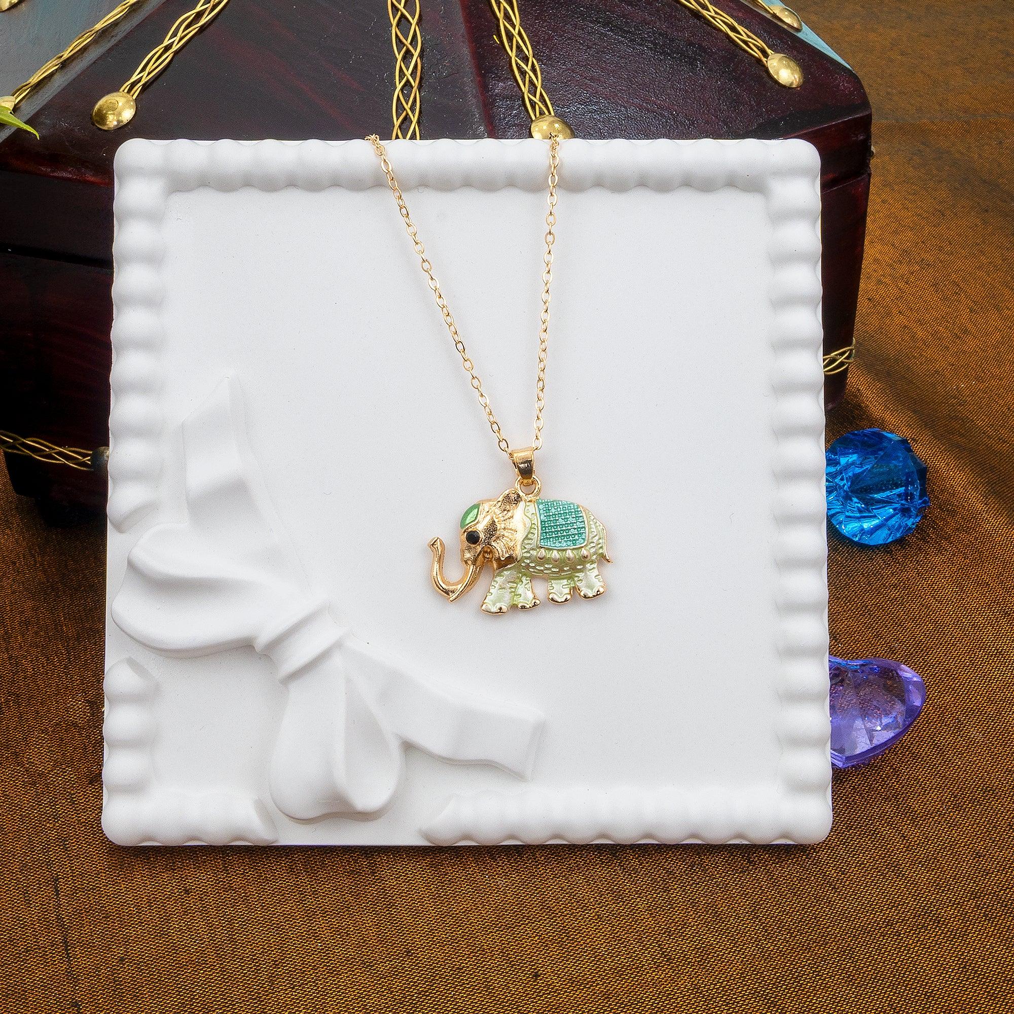 Gold elephant pendant necklace on a white decorative stand with a brown background