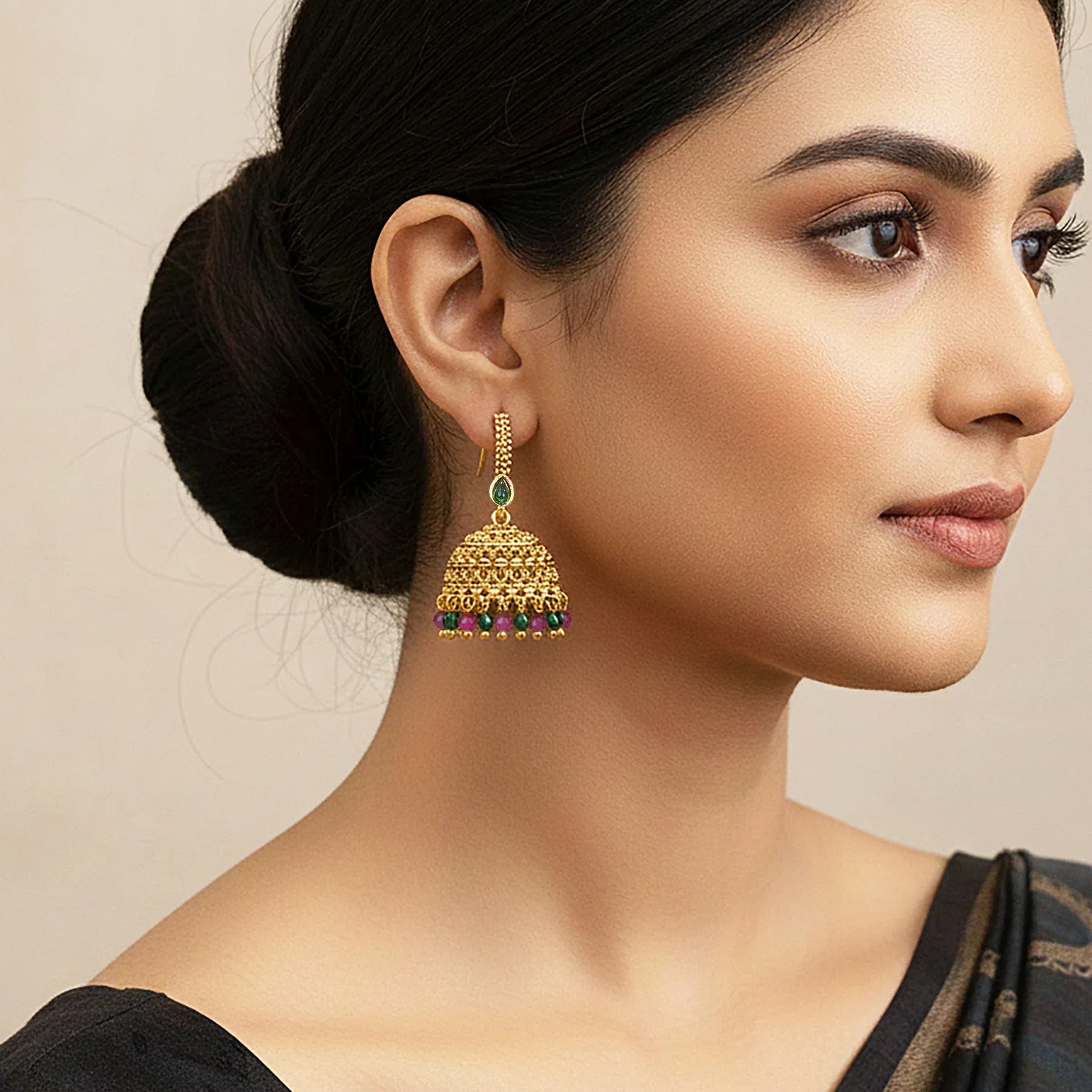 Woman wearing gold earrings with a neutral background
