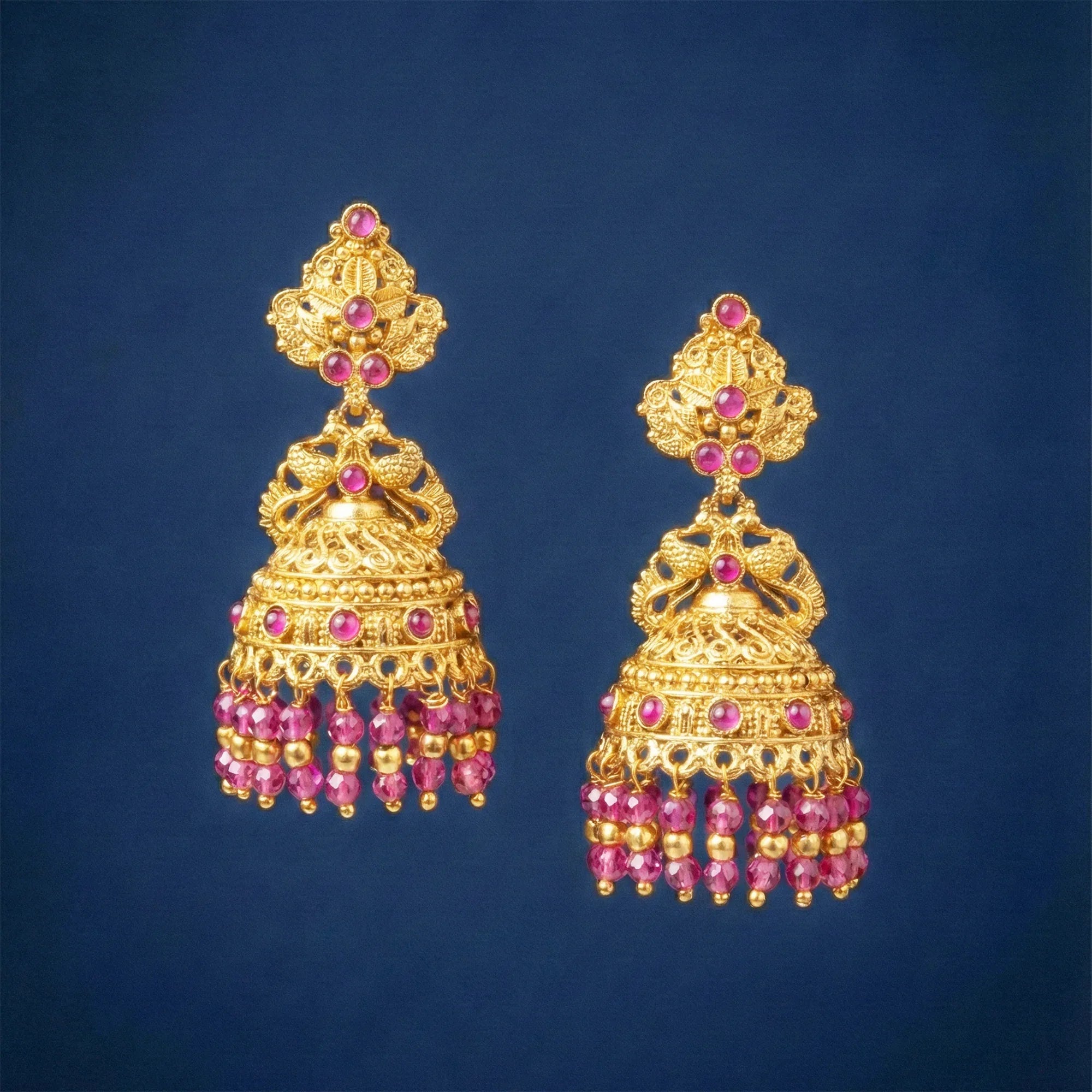 Gold and pink beaded earrings on a blue background